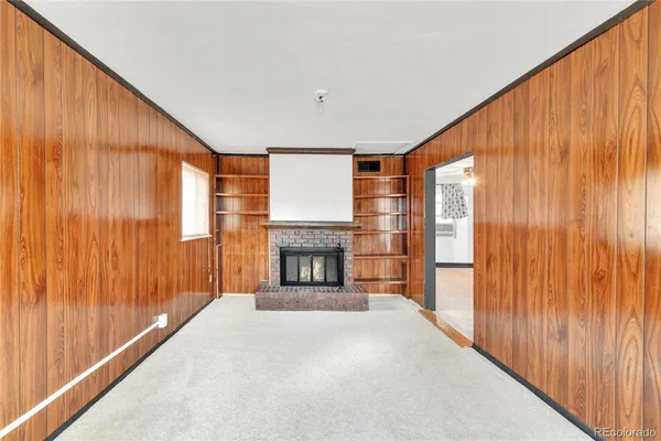 a view of an empty room with a fireplace and a window
