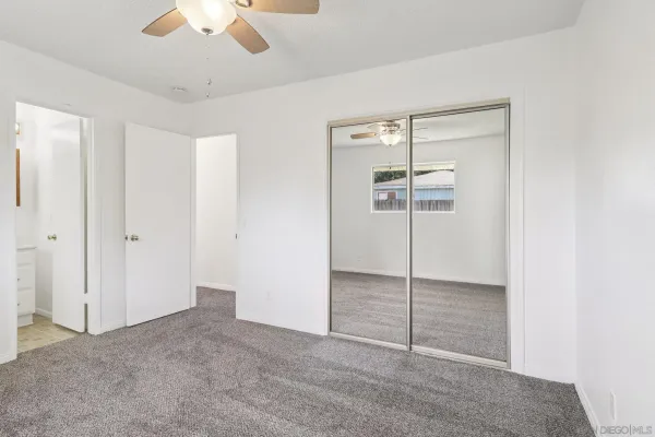 an empty room with a chandelier fan