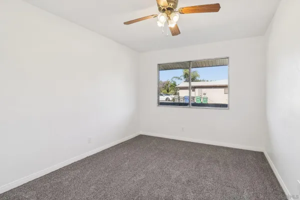 an empty room with a fan and a fan
