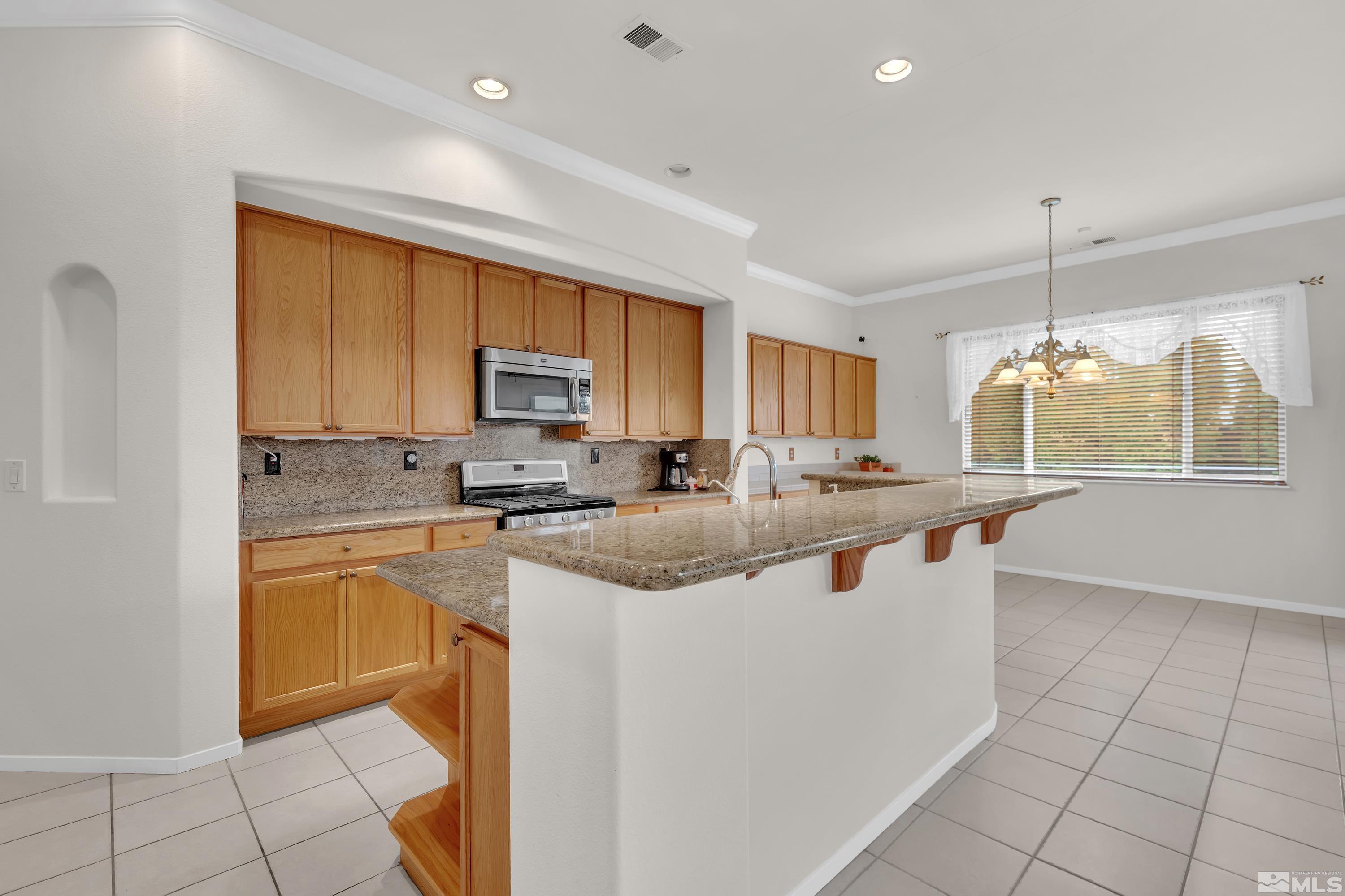 10690 Blue Moon Court Reno, NV 89521 - Photo 8 of 25 a kitchen with stainless steel appliances granite countertop a sink and a refrigerator