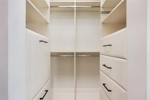 a bathroom with a walk in closet and a shower