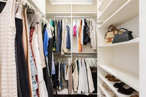a view of walk in closet with clothes and shoes