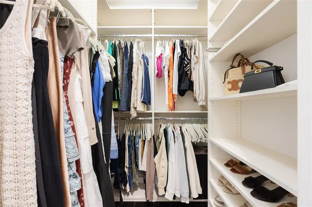 a view of walk in closet with clothes and shoes