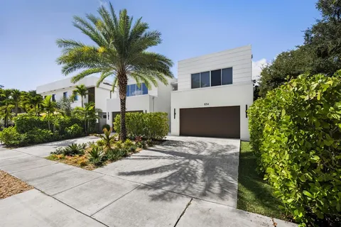 a front view of a house with a yard and potted plants