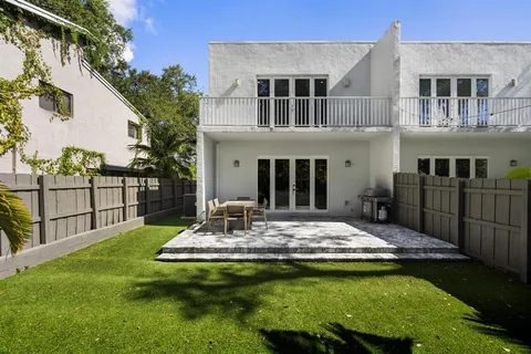 a view of a house with backyard and sitting area