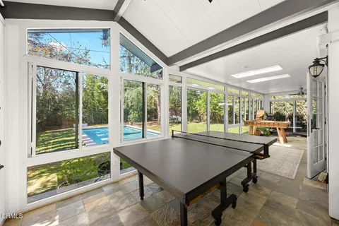 a room with pool table and windows