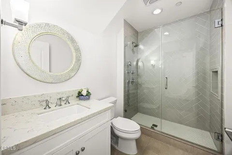 a bathroom with a granite countertop toilet a sink and a mirror