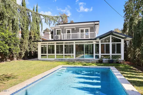 a view of an house with swimming pool and porch with furniture