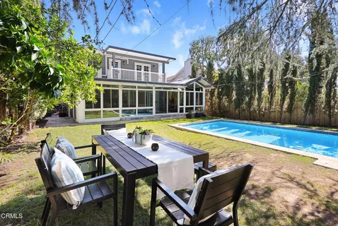 a view of a house with swimming pool and sitting area