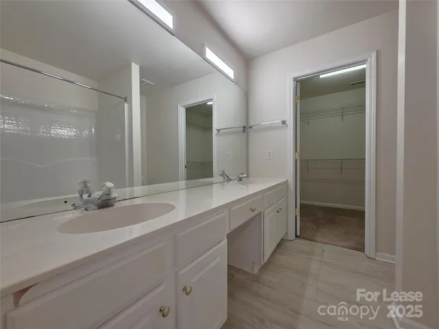 a bathroom with a double vanity sink and a mirror