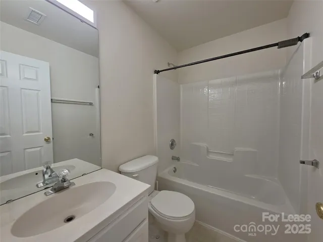 a bathroom with a sink mirror toilet and bathtub