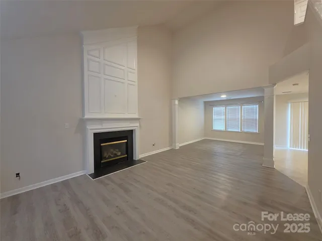 an empty room with windows and a fireplace
