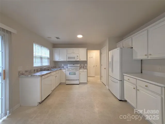a kitchen with white cabinets and white appliances