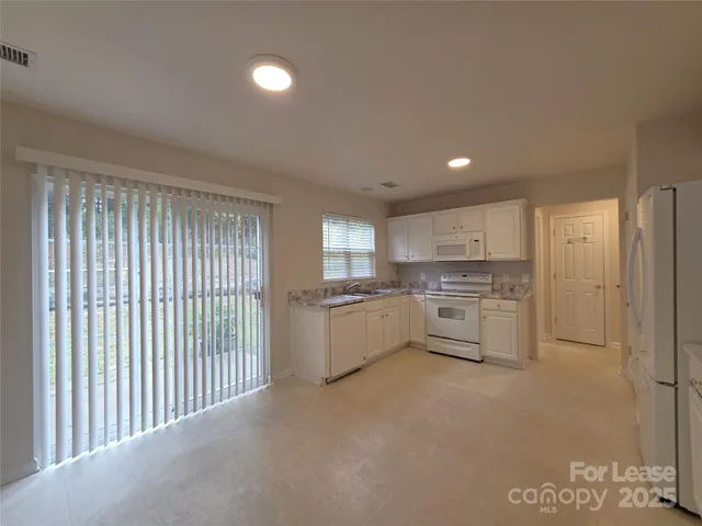 a kitchen with white cabinets and white appliances