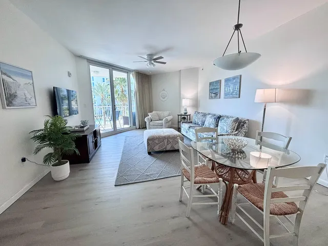 a living room with stainless steel appliances kitchen island granite countertop a rug and a wooden floor