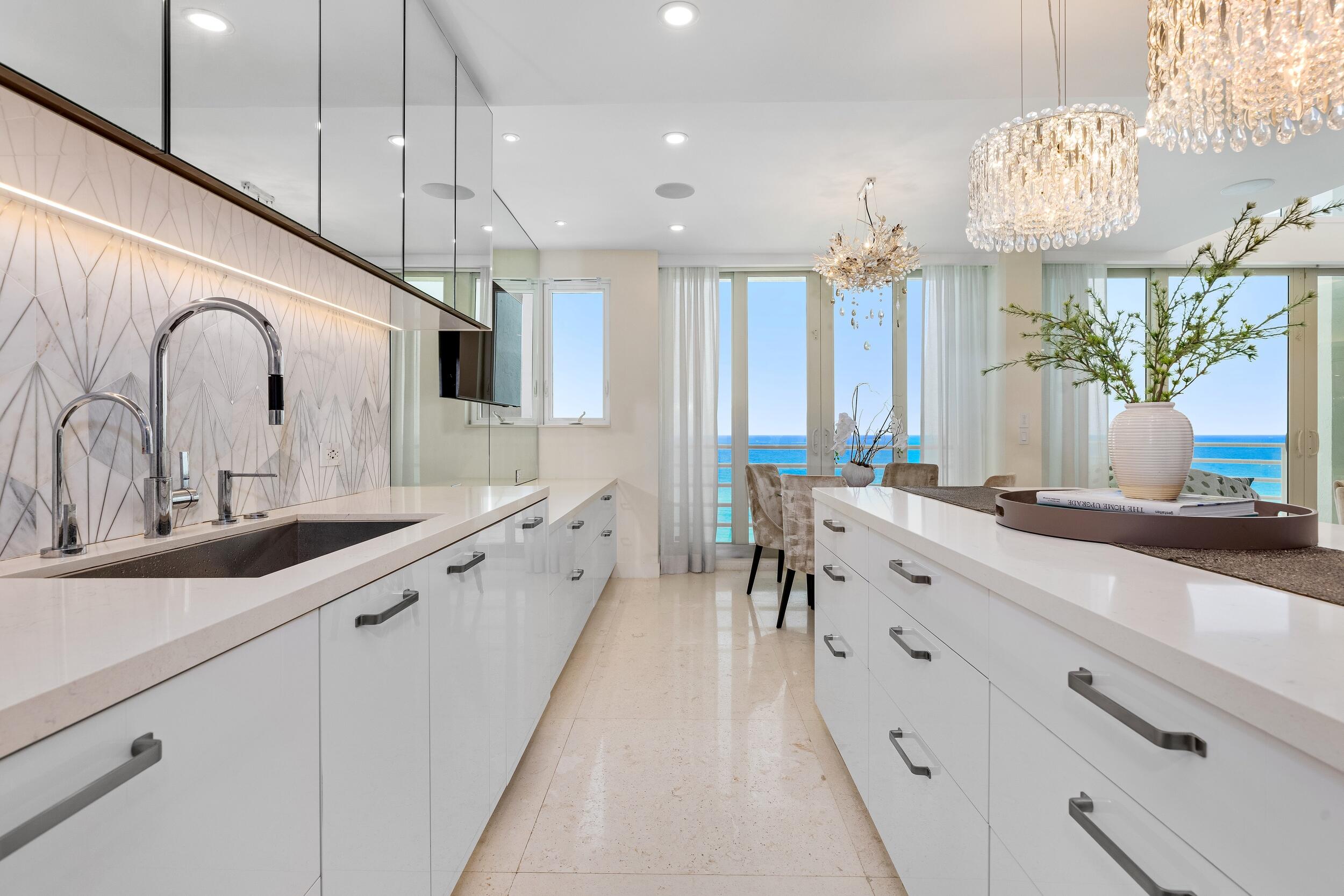 800 South Ocean Boulevard, Unit PH6 Boca Raton, FL 33432 - Photo 20 of 69 a large white kitchen with lots of counter space and chandelier