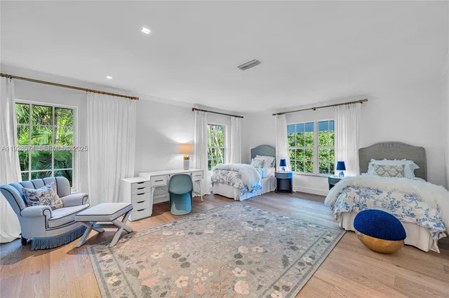 a bedroom with furniture and a large window