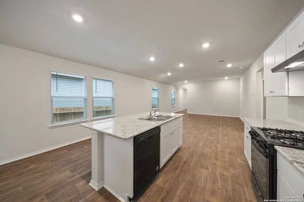 a kitchen with a sink stove and wooden cabinets
