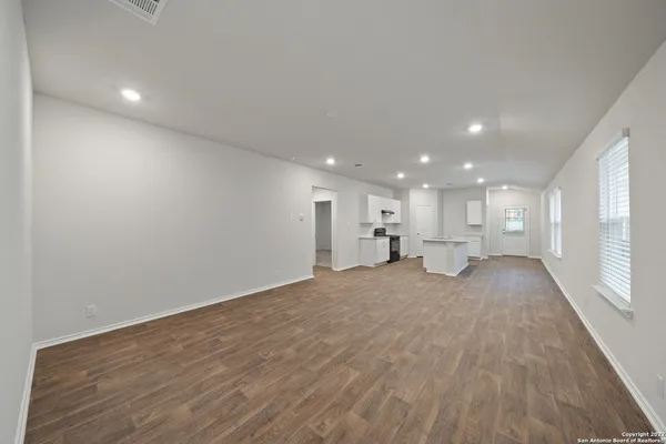 a view of a livingroom with kitchen and a window