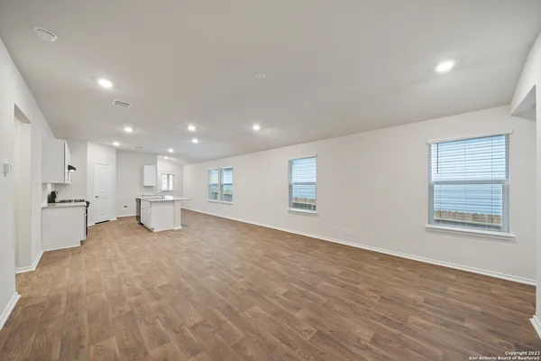 a view of a big room with wooden floor and windows