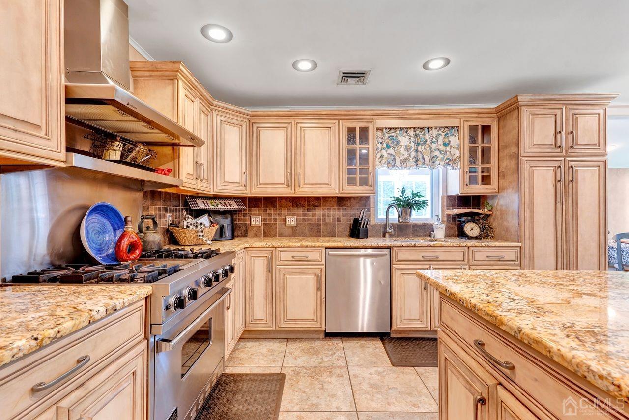 23 Valley Road Colonia, NJ 07067 - Photo 9 of 32 a kitchen with stainless steel appliances granite countertop a stove and a sink