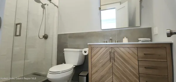 a bathroom with a sink a toilet and shower