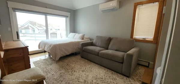 a bedroom with a bed couch and a window