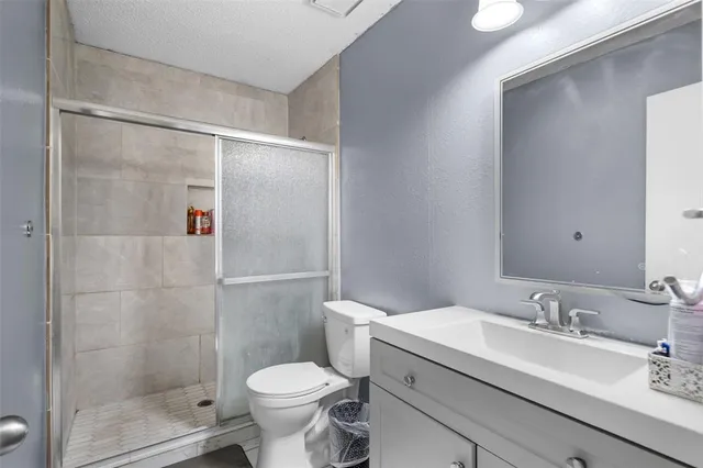a bathroom with a granite countertop sink toilet and shower