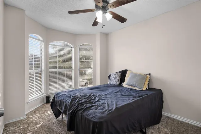 a large bed sitting in a bedroom next to a window