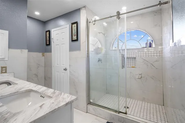 a bathroom with a shower sink and mirror