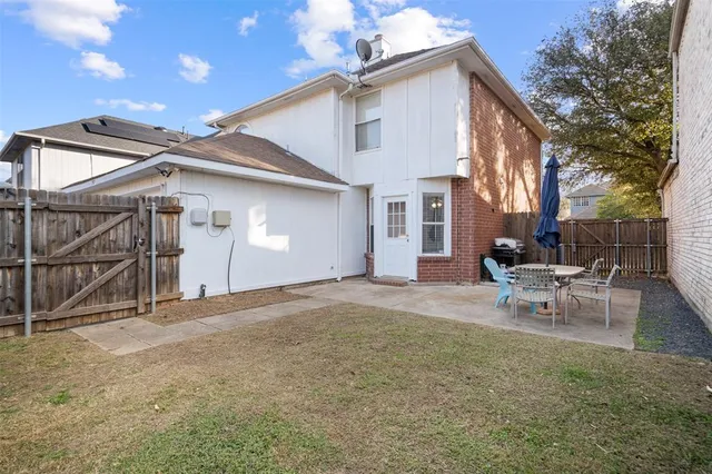 a view of a house with backyard and a tree