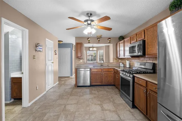 a kitchen with stainless steel appliances granite countertop a stove refrigerator sink and dishwasher with wooden floor