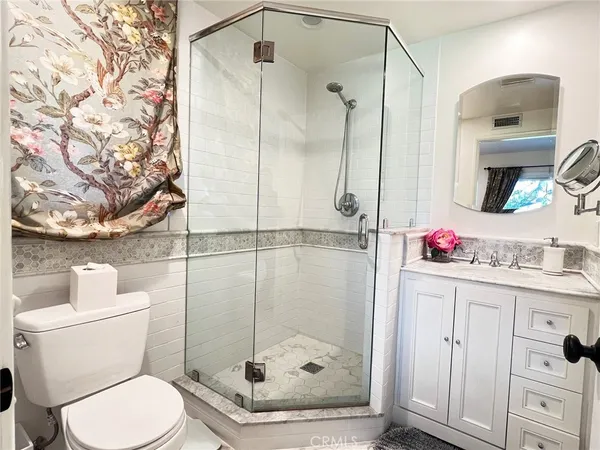a bathroom with a shower sink vanity and toilet