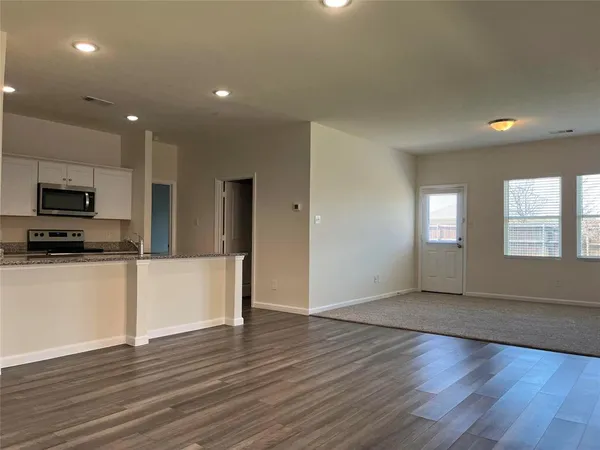 a kitchen with stainless steel appliances wooden floors and wooden cabinets