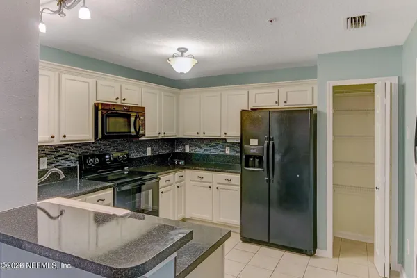 a kitchen with a sink appliances and cabinets