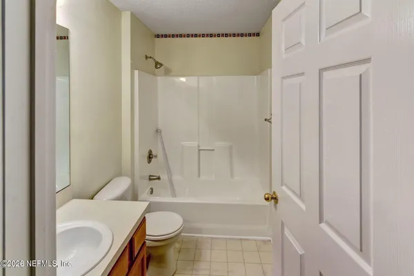 a bathroom with a granite countertop toilet and a shower