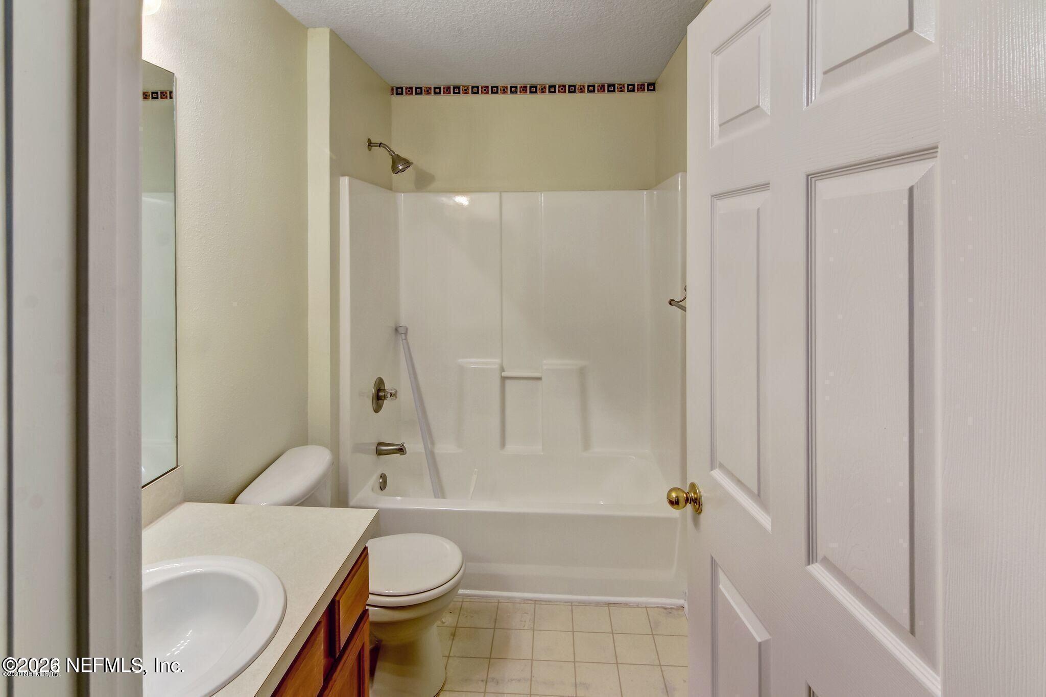 6057 Maggies Circle, Unit 110 Jacksonville, FL 32244 - Photo 6 of 9 a bathroom with a granite countertop toilet and a shower