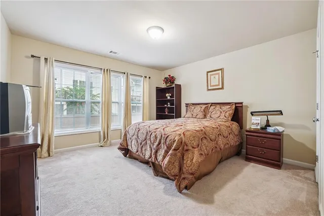 a spacious bedroom with a bed and a large window