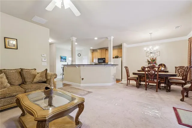 a living room with furniture and a dining table with kitchen view