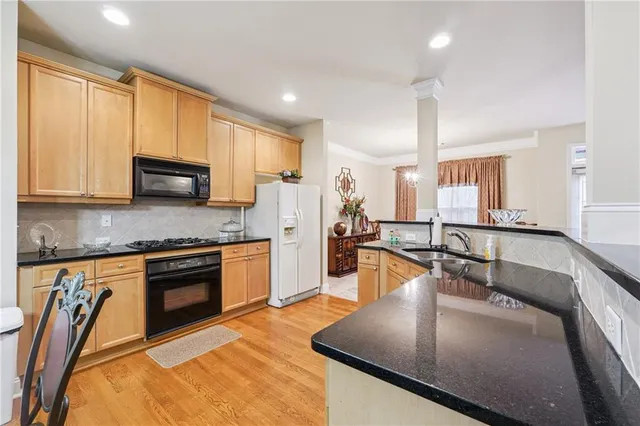 a kitchen with stainless steel appliances granite countertop a sink stove and microwave
