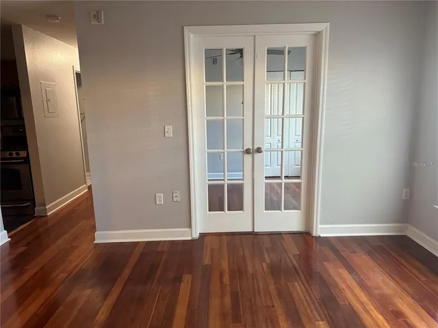 an empty room with wooden floor and a fireplace