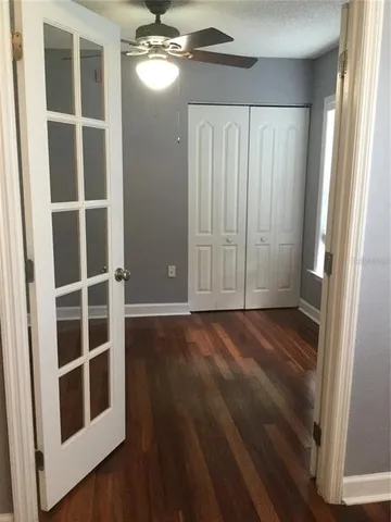 a view of an empty room with a window and wooden floor