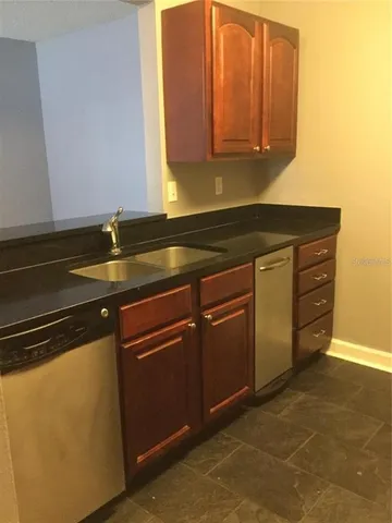 a kitchen with granite countertop a sink and cabinets