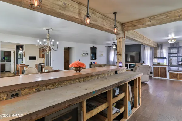 a large kitchen with stainless steel appliances granite countertop a stove top oven a sink dishwasher a dining table and chairs with wooden floor