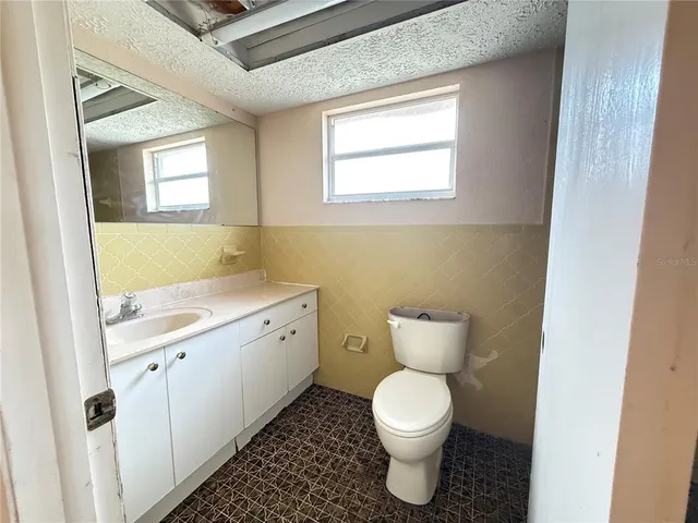 a bathroom with a toilet sink and mirror