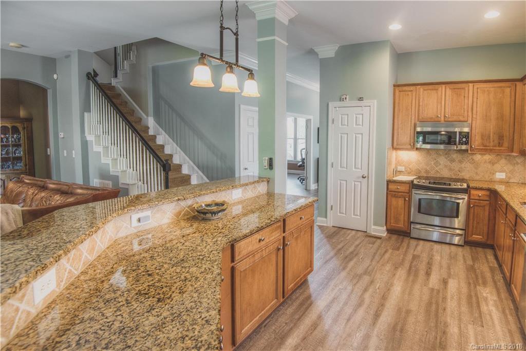 122 Mills Lane Fort Mill, SC 29708 - Photo 6 of 36 a kitchen with stainless steel appliances granite countertop a kitchen island a hardwood floor and a sink