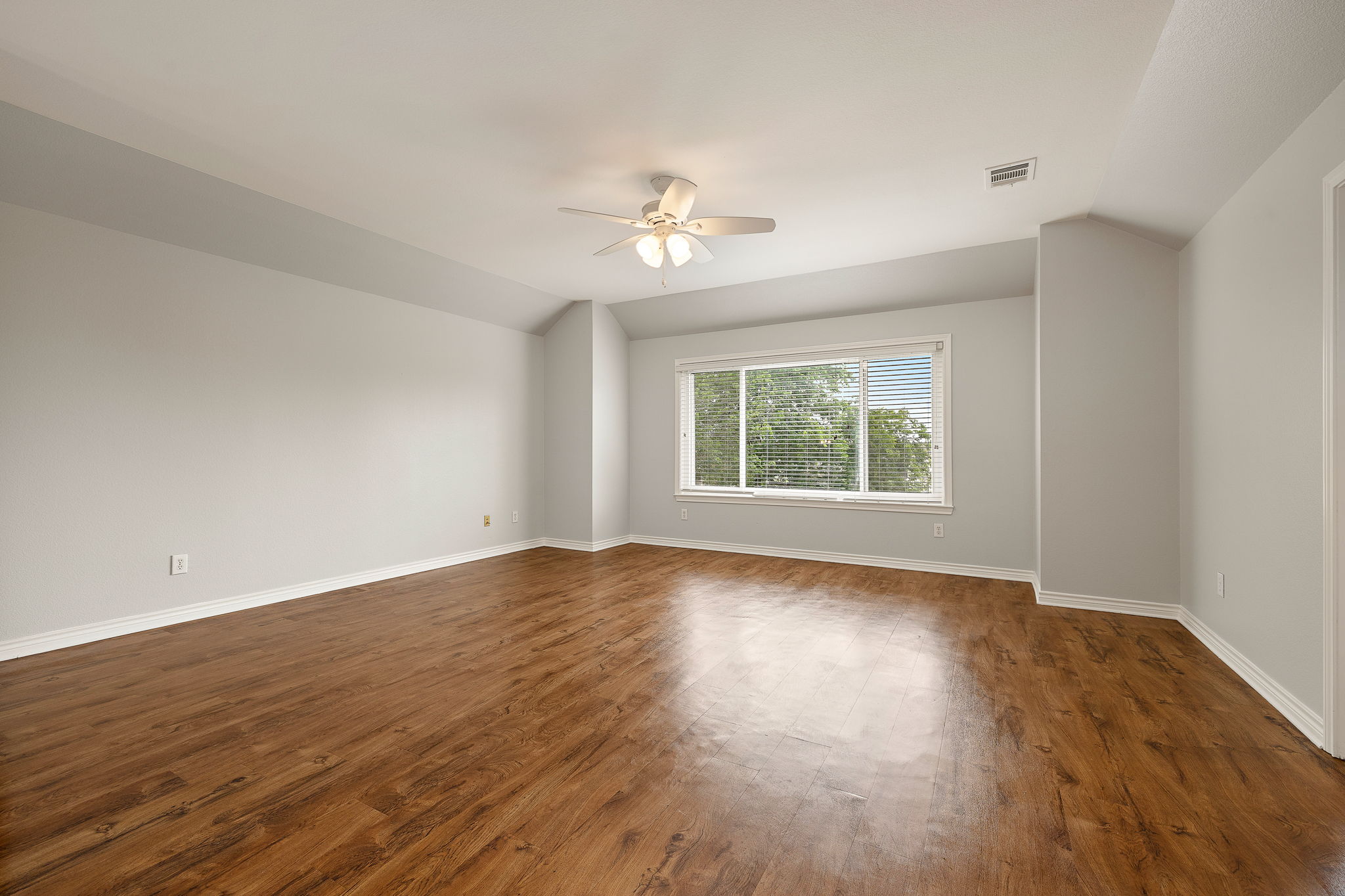 202 Nick Price Loop Round Rock, TX 78664 - Photo 25 of 39 an empty room with wooden floor ceiling fan and windows