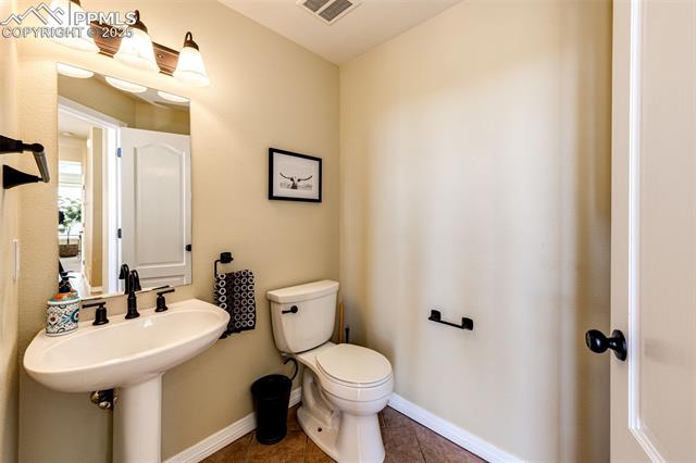 19340 Furrow Road Monument, CO 80132 - Photo 19 of 50 Half bathroom with baseboards, visible vents, tile patterned floors, and toilet