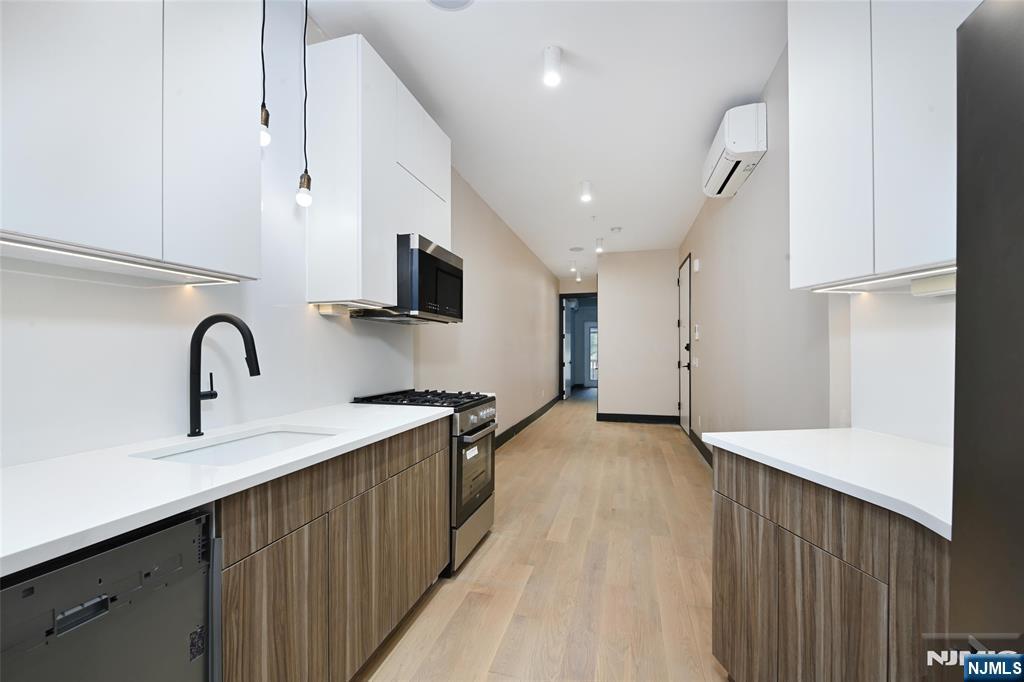 208 15th Street Jersey City, NJ 07310 - Photo 11 of 46 a view of a kitchen with stainless steel appliances a refrigerator and a sink