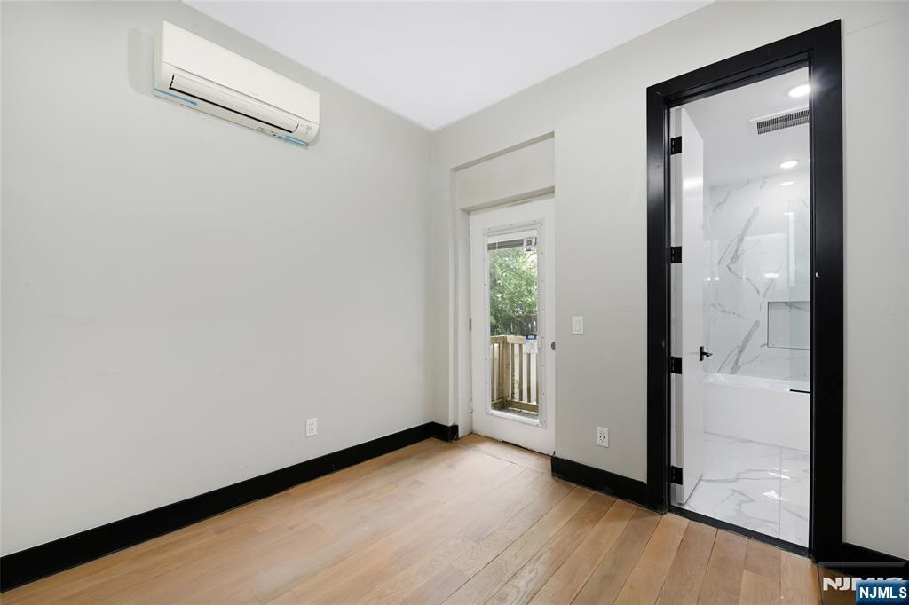 208 15th Street Jersey City, NJ 07310 - Photo 17 of 46 a view of a hallway with wooden floor and a living room